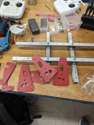Fabricated pink armor mounting plates arranged beside a robot chassis