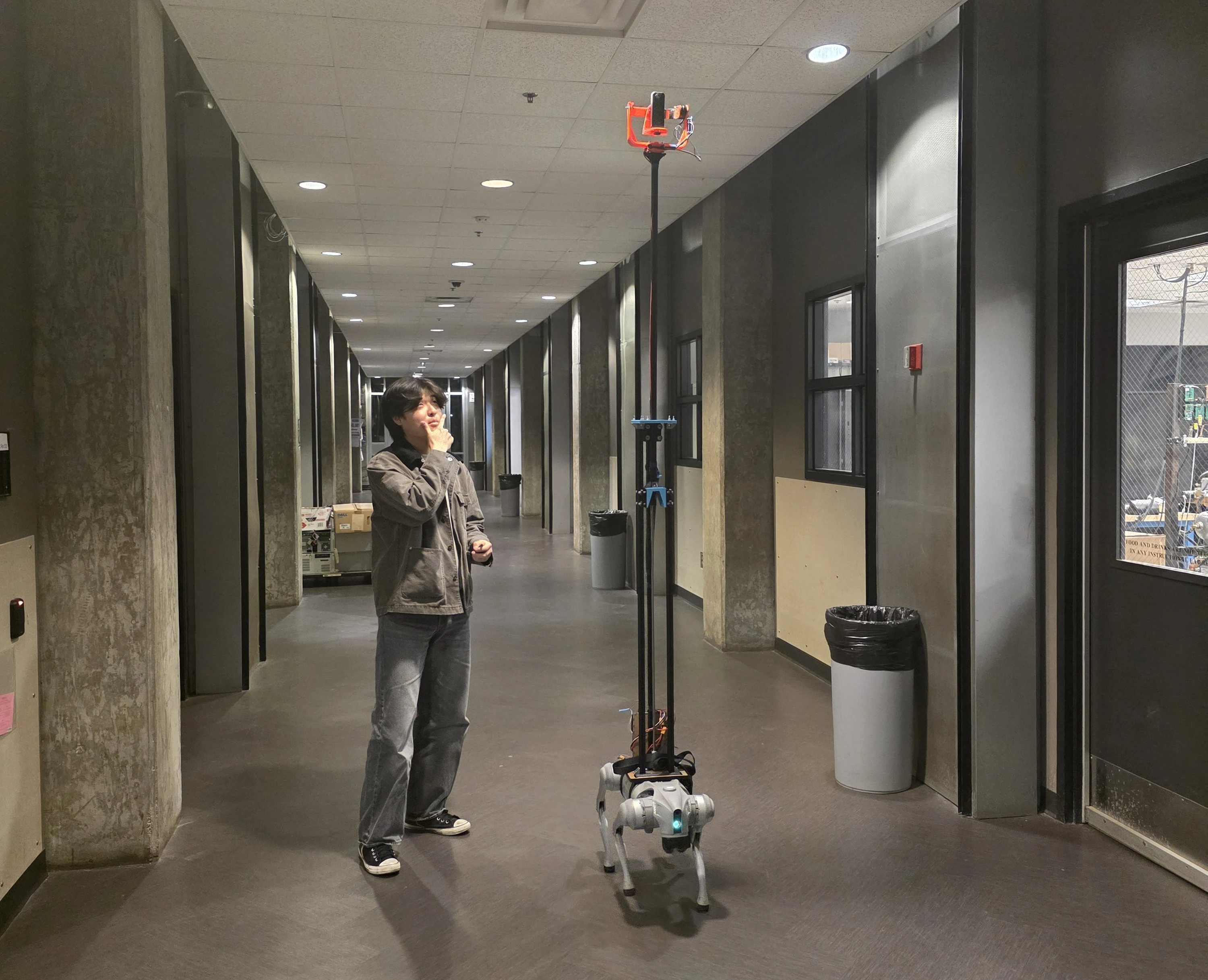 Justin Park beside the completed camera rig mounted on a quadruped robot in a hallway
