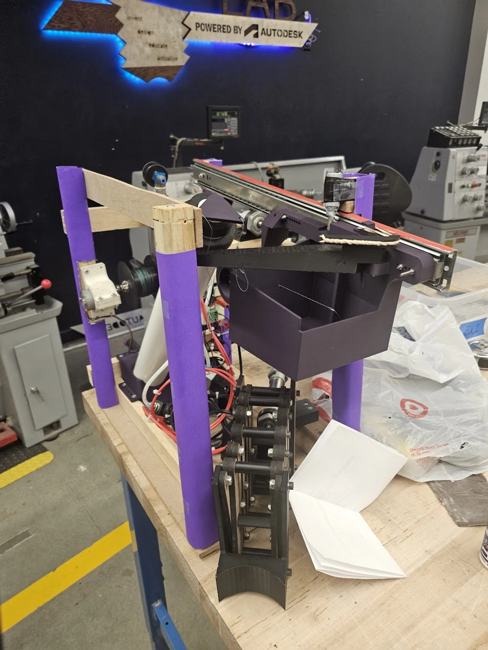 Completed Mind-inator robot with compact mechanisms, wooden frame, printed parts, and onboard actuation